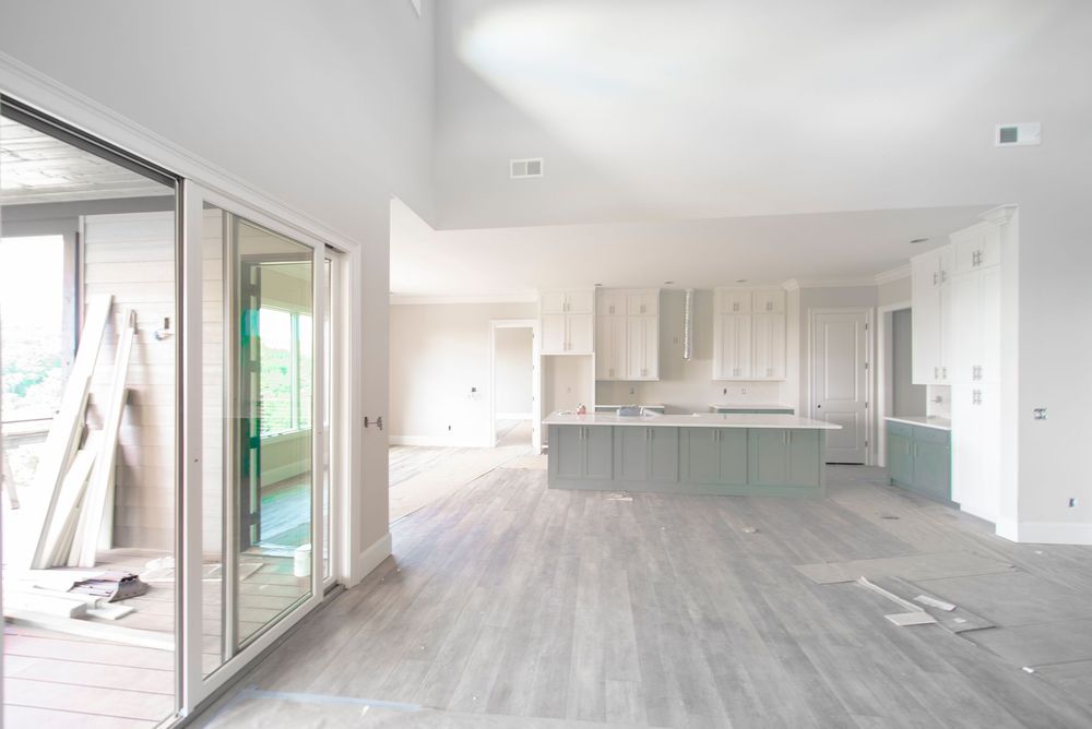 Una grande stanza vuota con una cucina e porte scorrevoli in vetro.