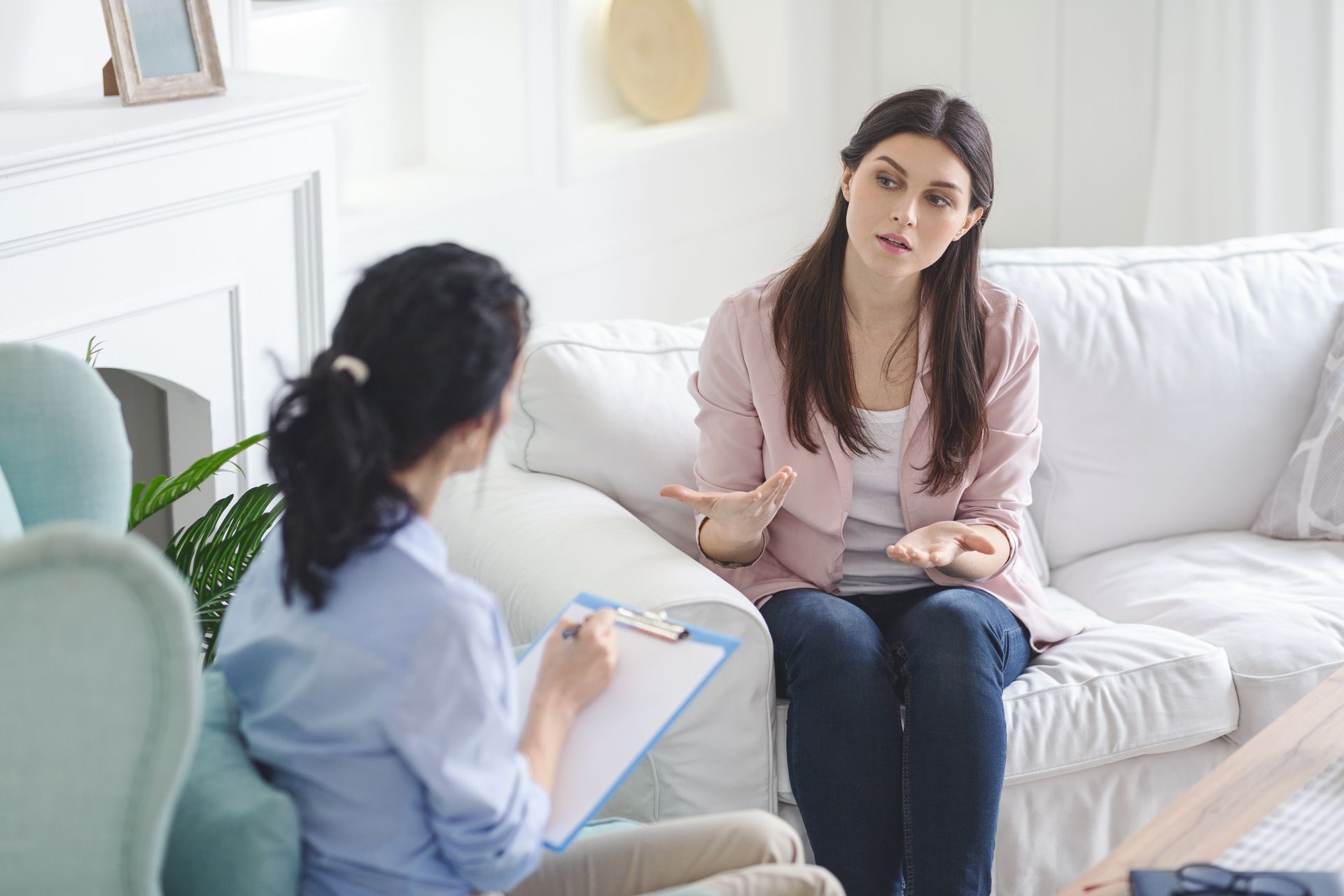 Emotional young woman sharing her feelings with psychotherapist at regular session