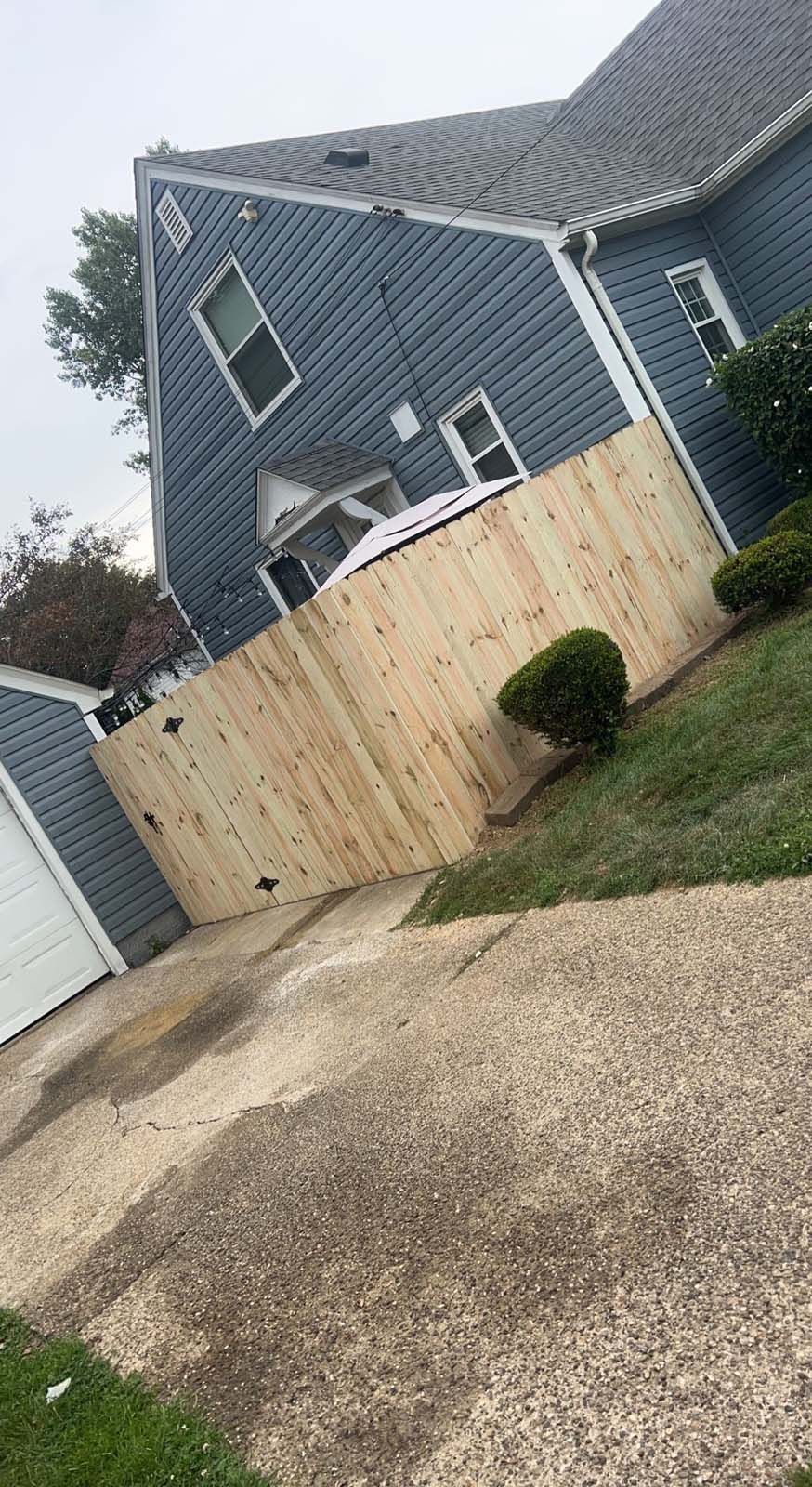 A blue house with a wooden fence in front of it.