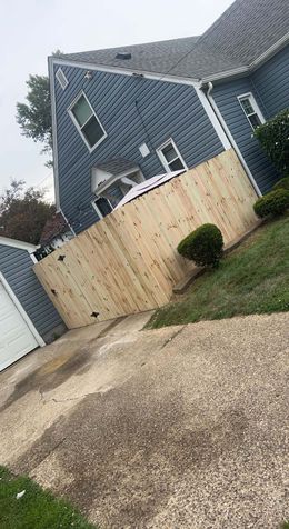 A blue house with a wooden fence in front of it.