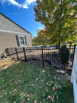 There is a fence in the backyard of a house.
