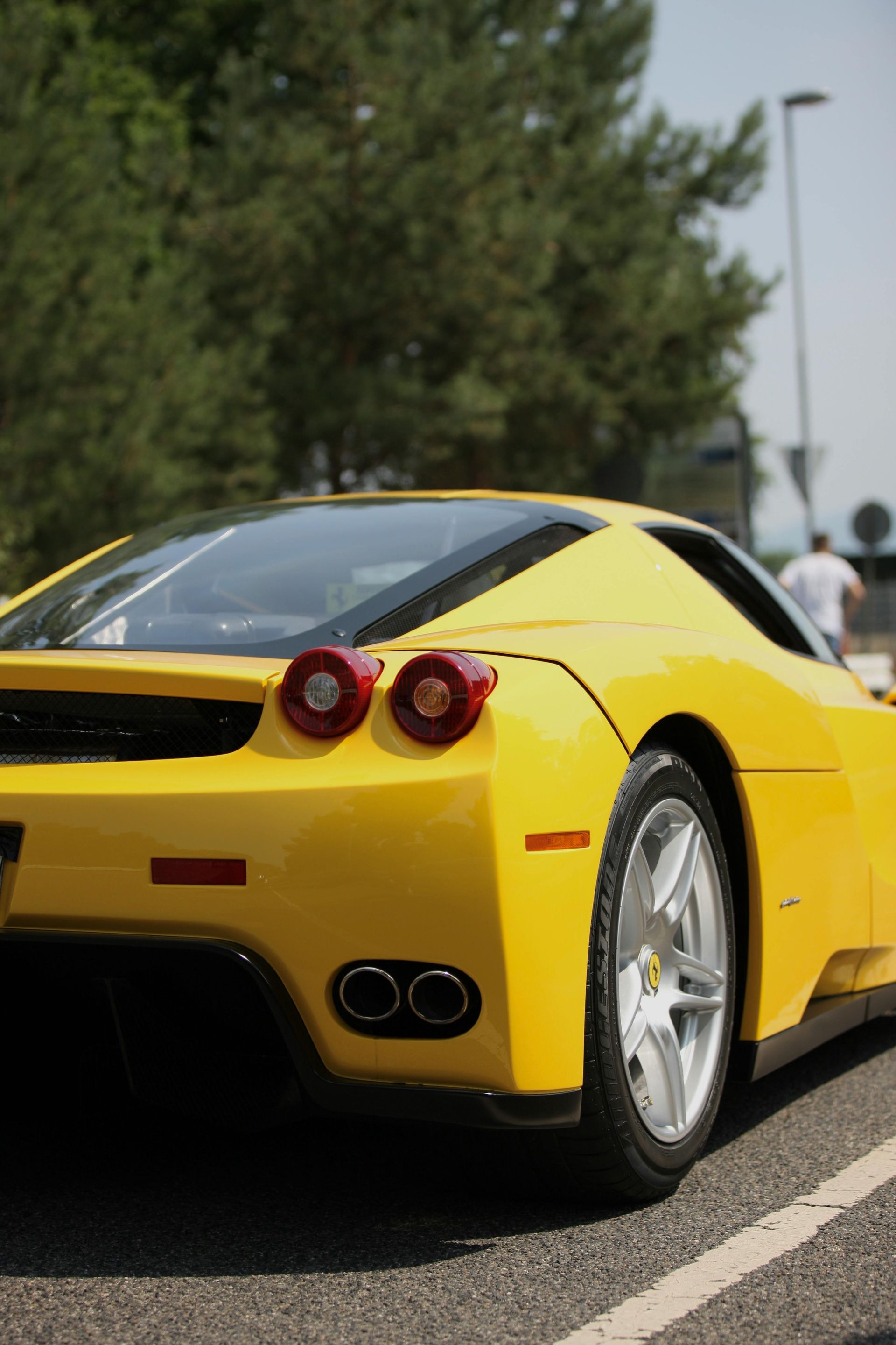 A yellow sports car is parked in a parking lot