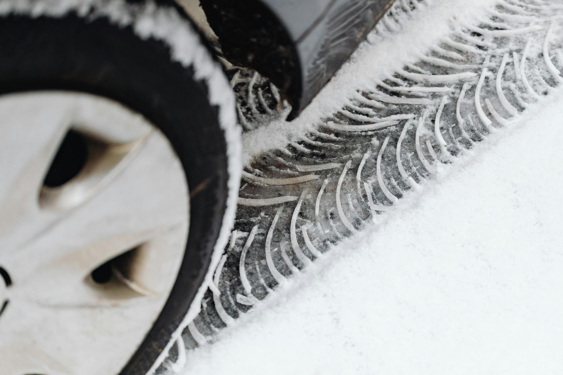 A close up of a car tire in the snow.