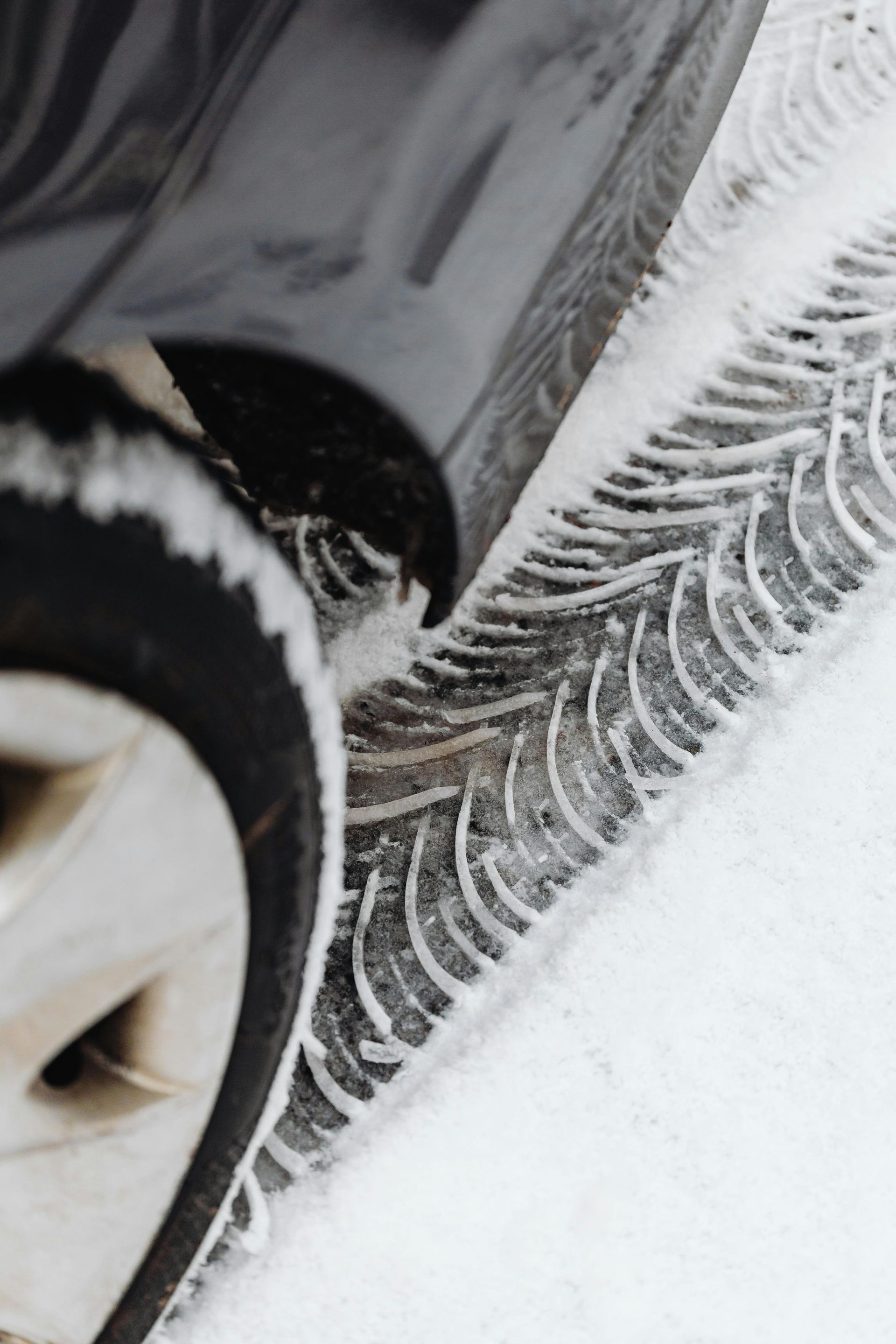 A close up of a car tire in the snow.