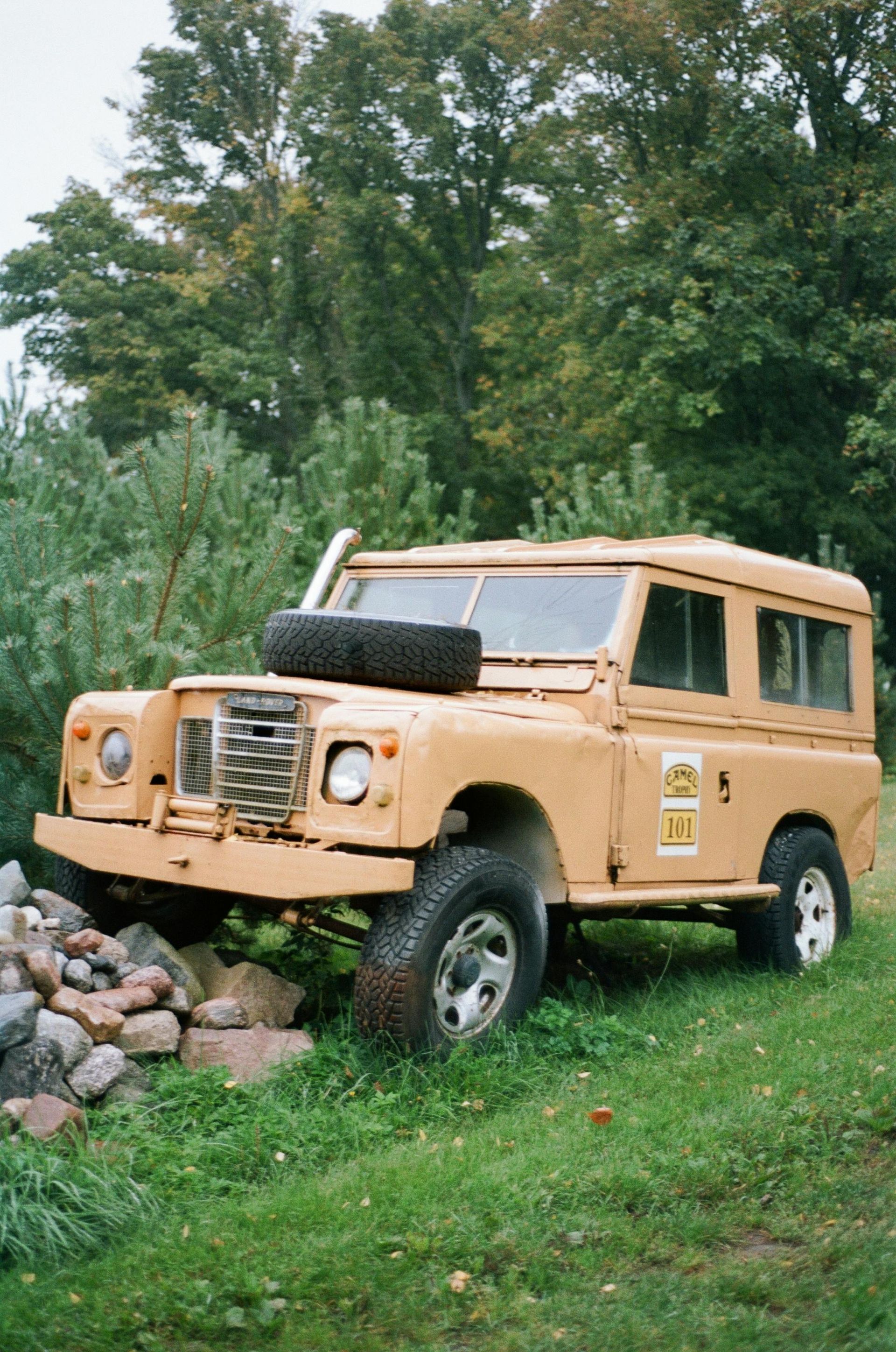 A motorcycle with a helmet on the handlebars is parked on a brick street.