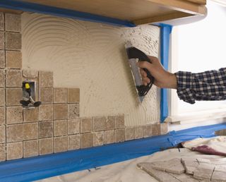 Man putting tiles on wall — Home Improvement in Roswell, NM
