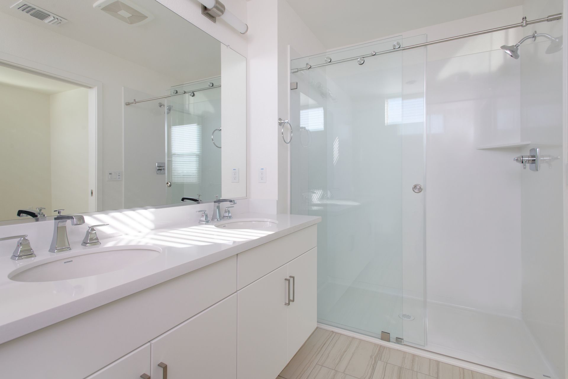 photo showing dual vanity mirror and shower with glass doors