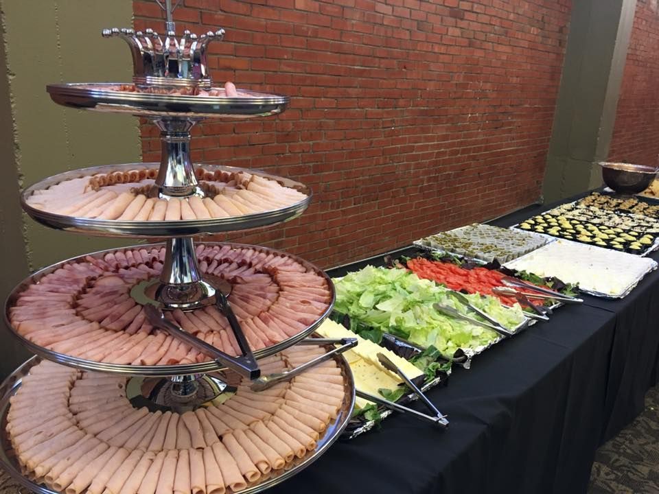A buffet table with a tray of soup and a tray of food.