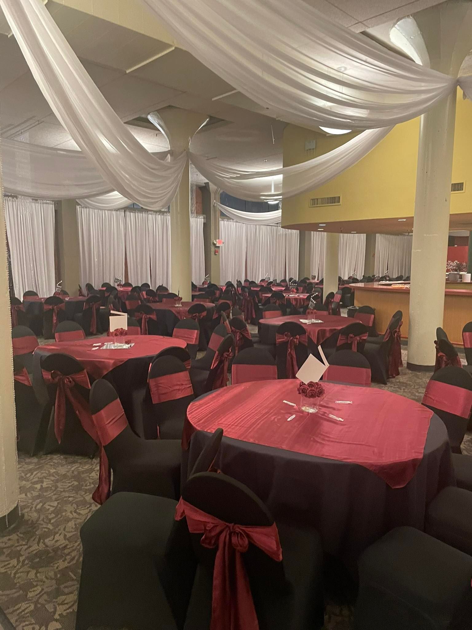 A large room with tables and chairs set up for a party.