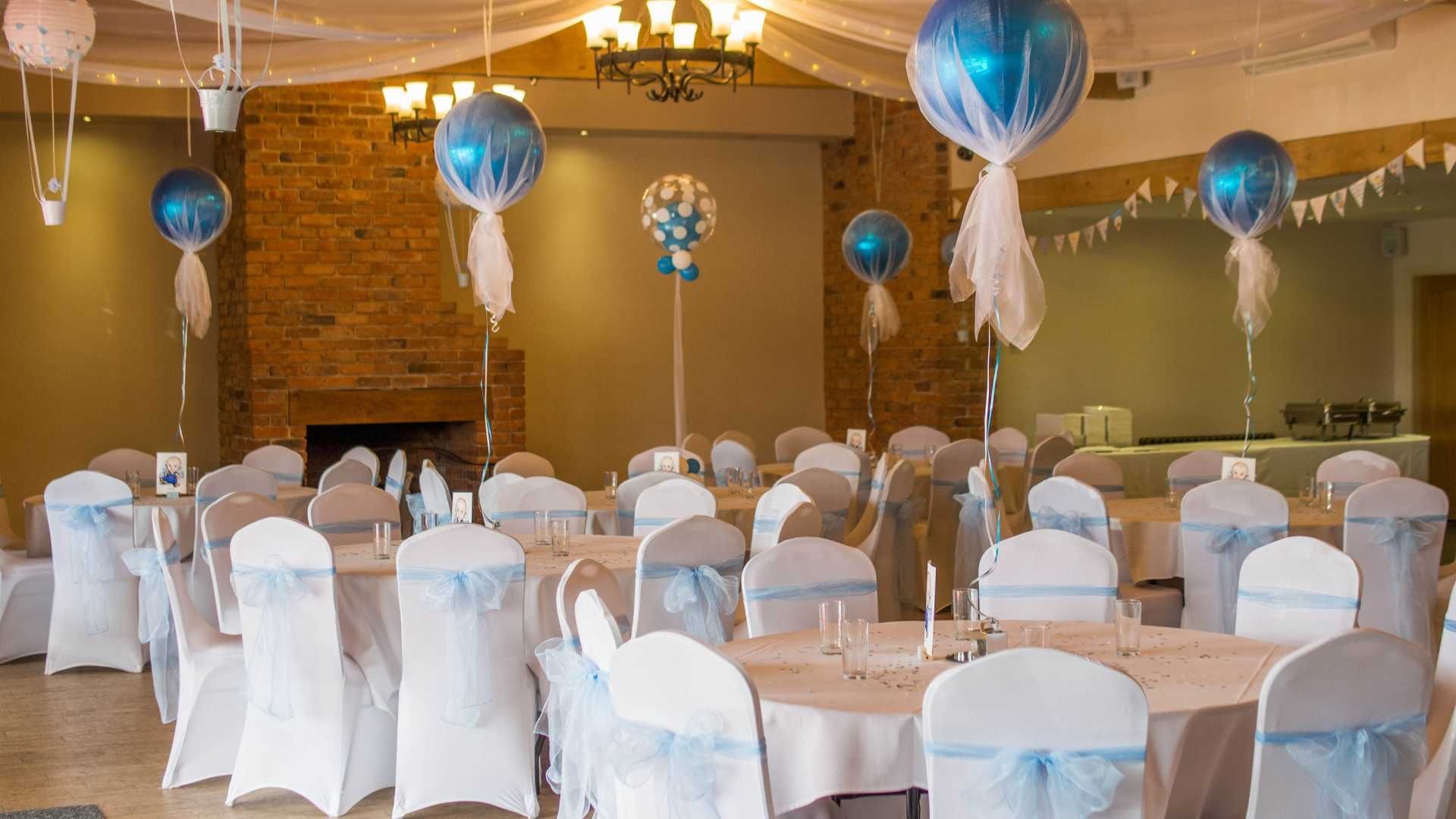 A room filled with tables and chairs decorated for a baby shower.