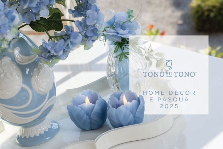 Due candele blu sono appoggiate su un tavolo accanto a un vaso di fiori blu.