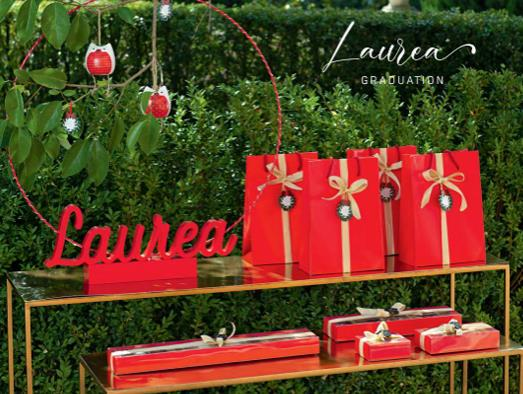 Un tavolo con regali rossi e un cartello con la scritta laurea