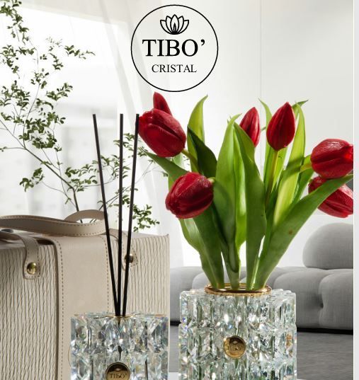 Due bottiglie di profumo sono appoggiate su un tavolo accanto a una rosa