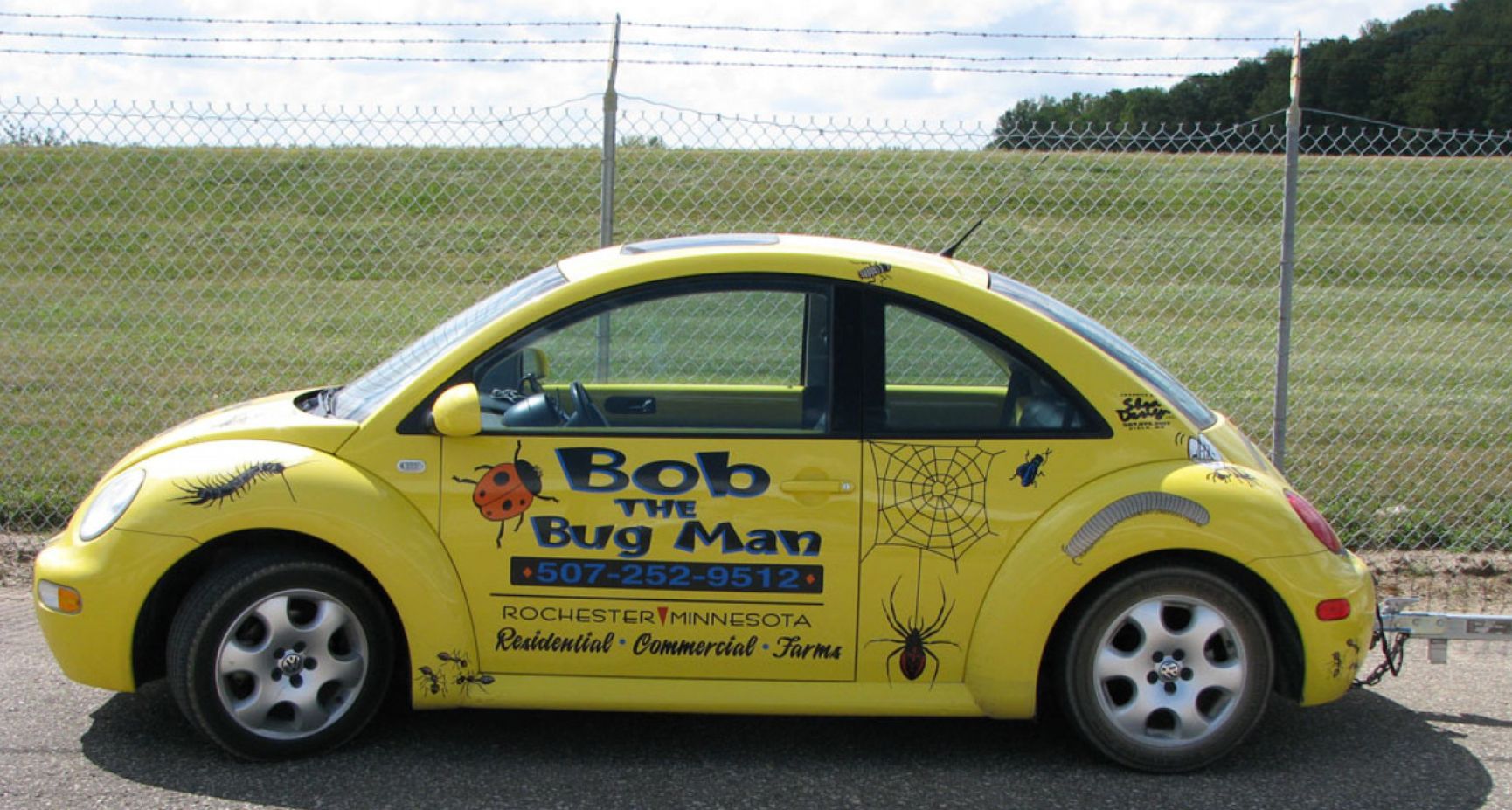 A yellow car with bob the bug man written on the side