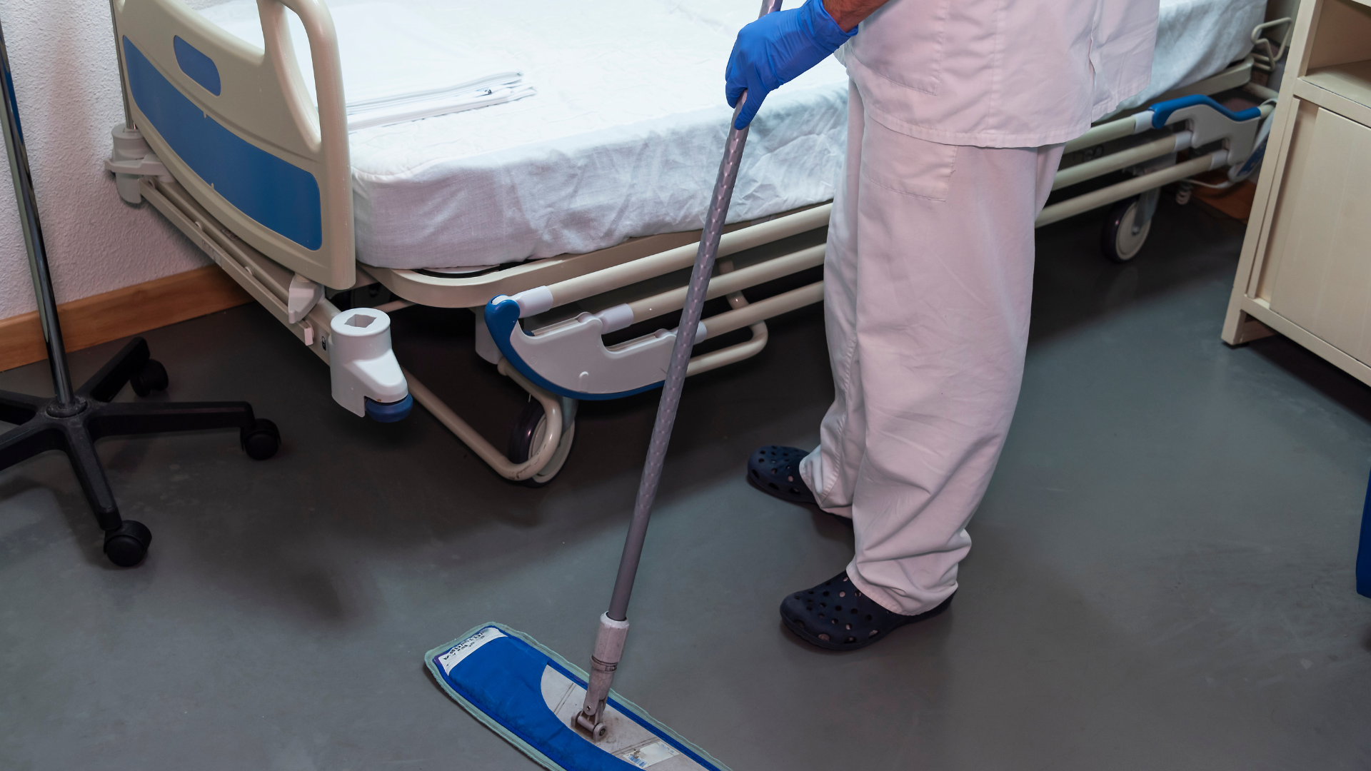 Person mopping a hospital room floor.