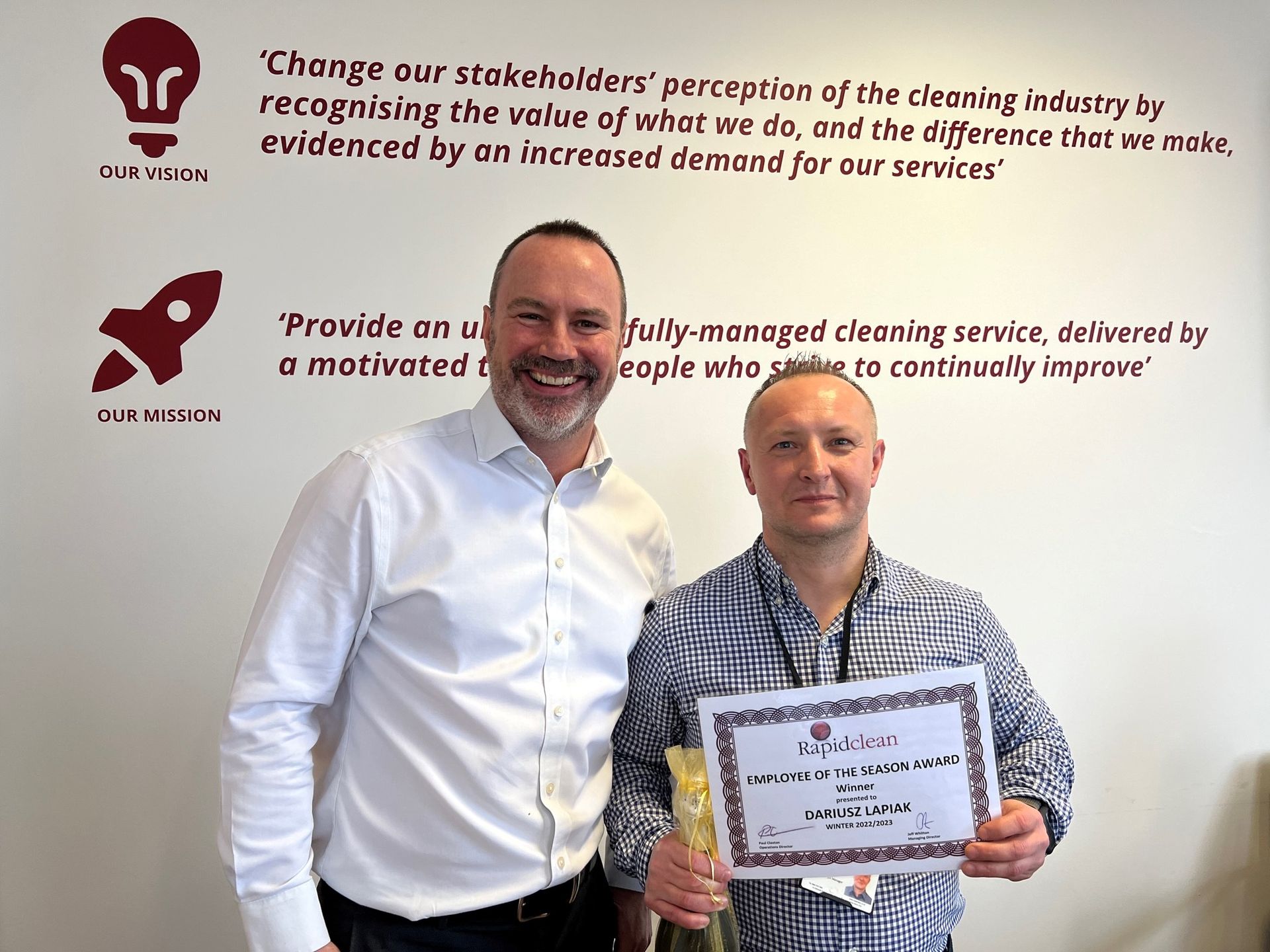 Two men are standing next to each other holding a certificate