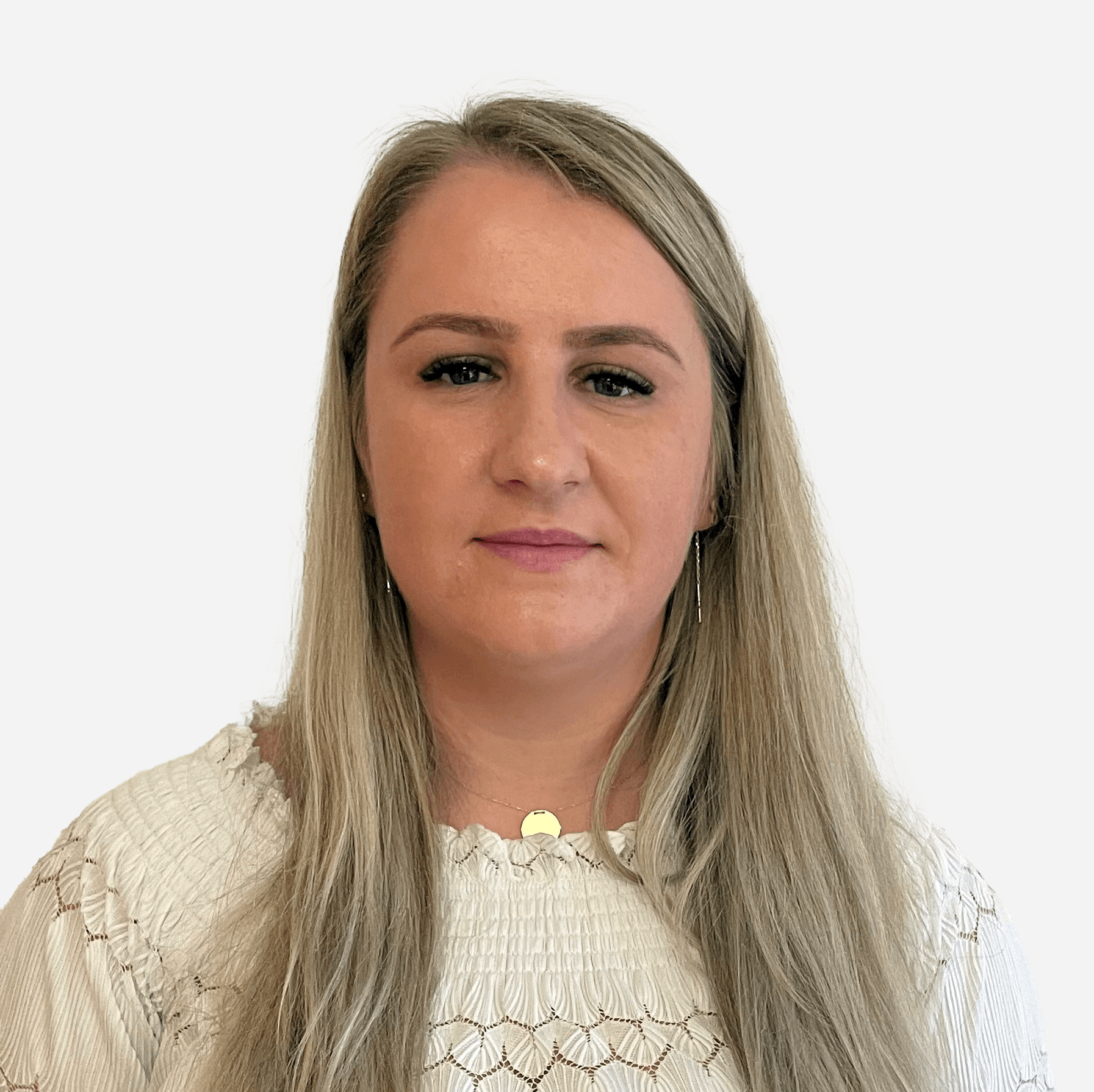 A woman with long blonde hair is wearing a white sweater and a gold necklace.