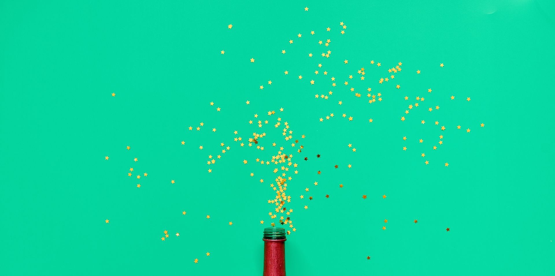 Green background and celebratory starts coming out of bottle