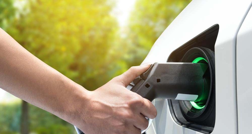 A person is charging an electric car at a charging station.