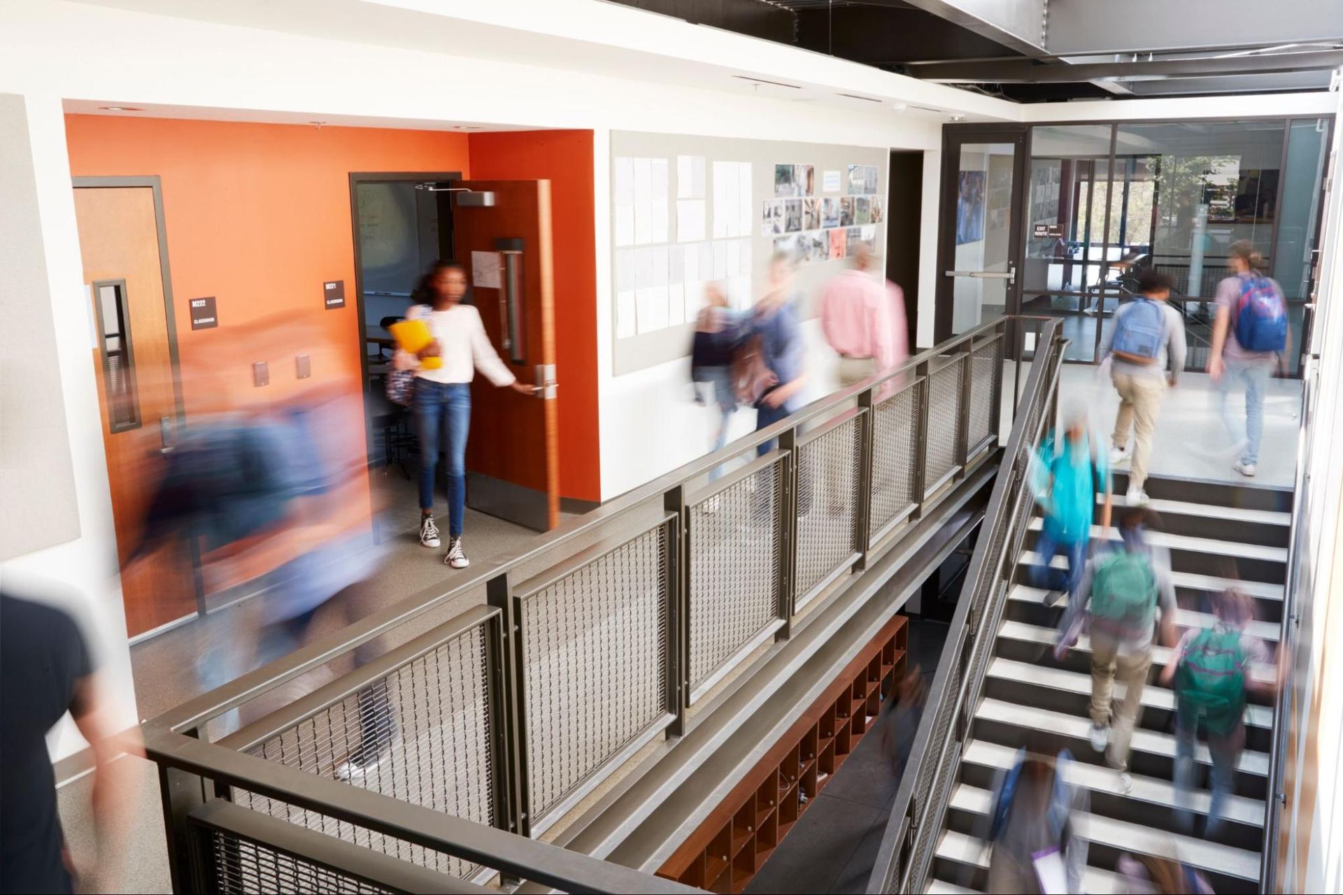 A group of people are walking down a hallway and stairs.