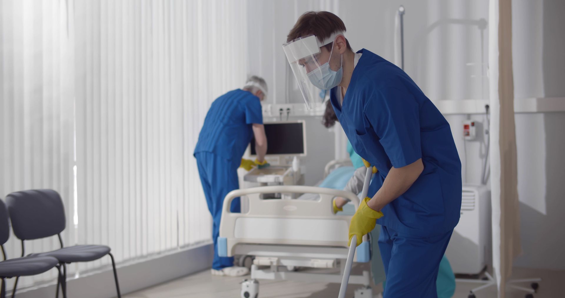 A team of professional cleaners are cleaning a hospital room