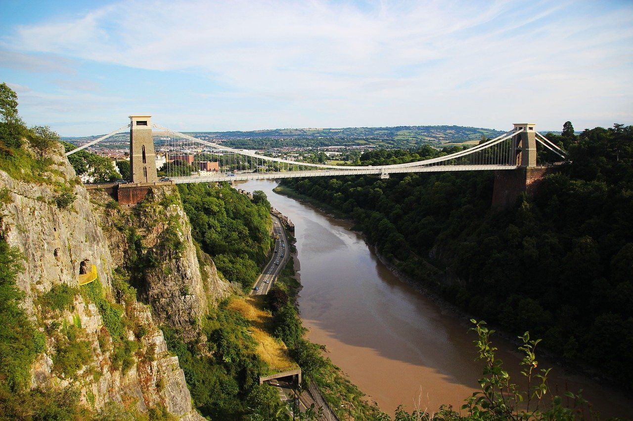 A bridge over a river surrounded by trees and rocks.