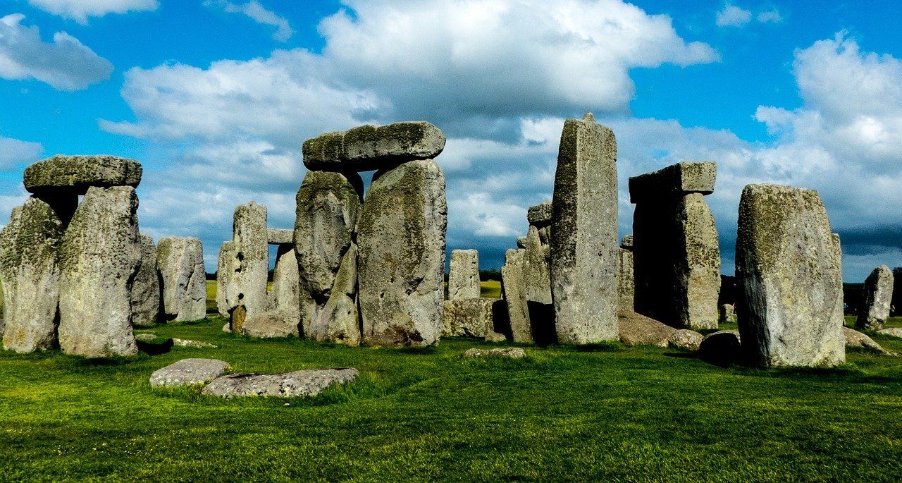 A group of rocks sitting on top of a lush green field.