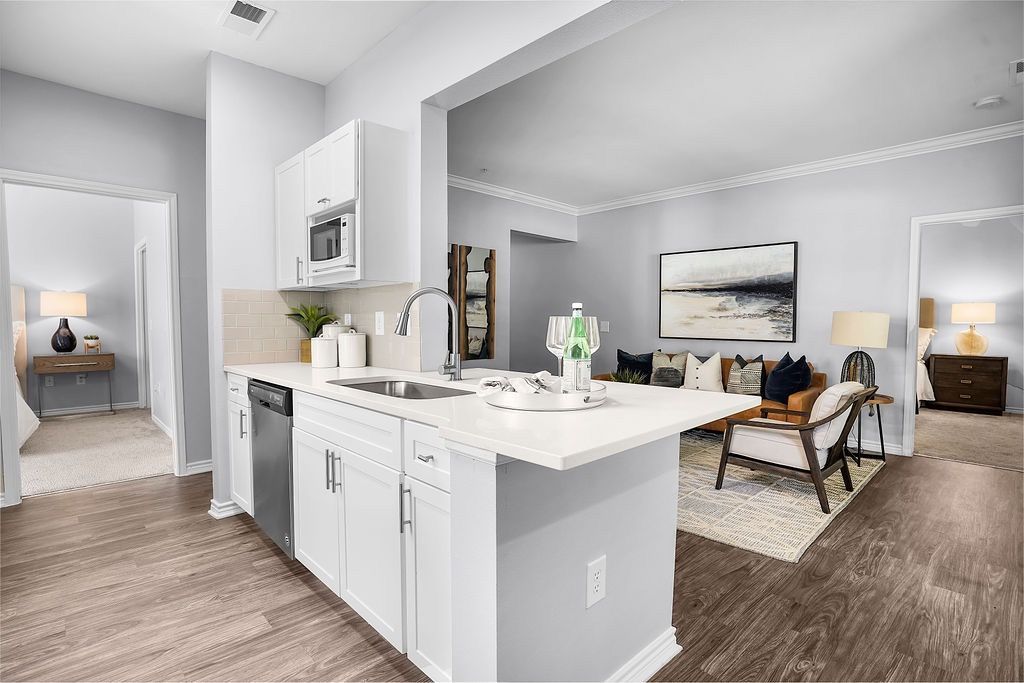 Open-concept kitchen with island and sink, connected to living area.