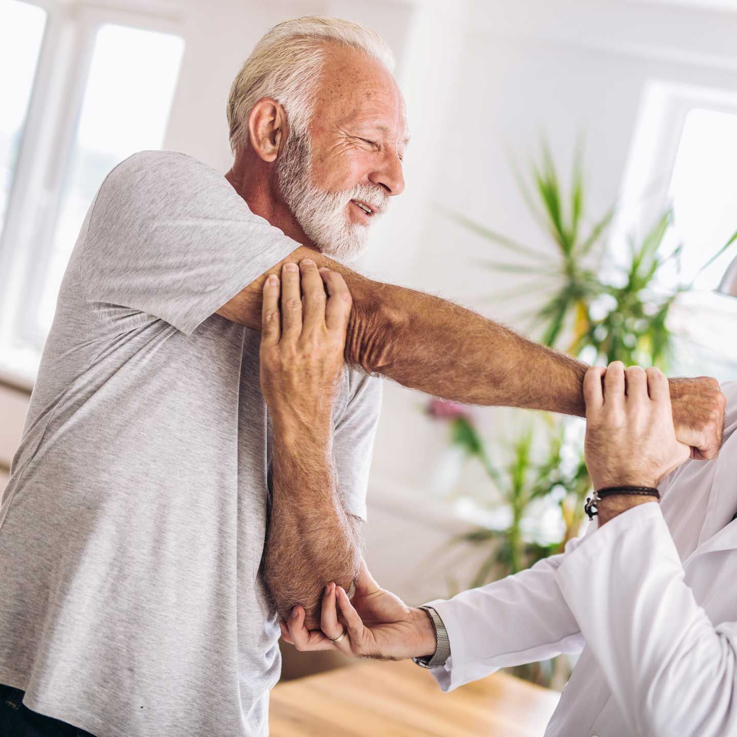 A healthcare professional providing spinal adjustment to a patient lying on a treatment table.