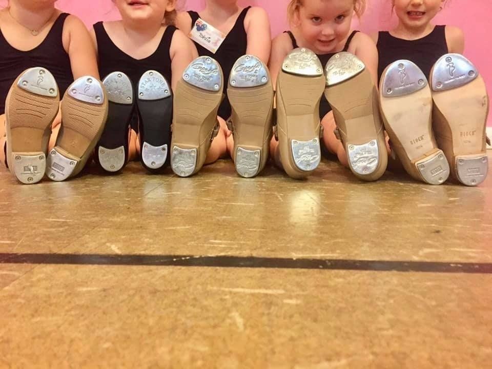 Tap Dancers Showing Bottom of Tap Shoes — Dance Classes in Gateshead, NSW