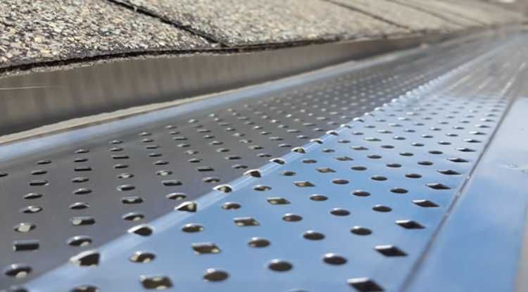 A metal perforated gutter guard installed on a home in Huntsville, AL by LJ Roofing