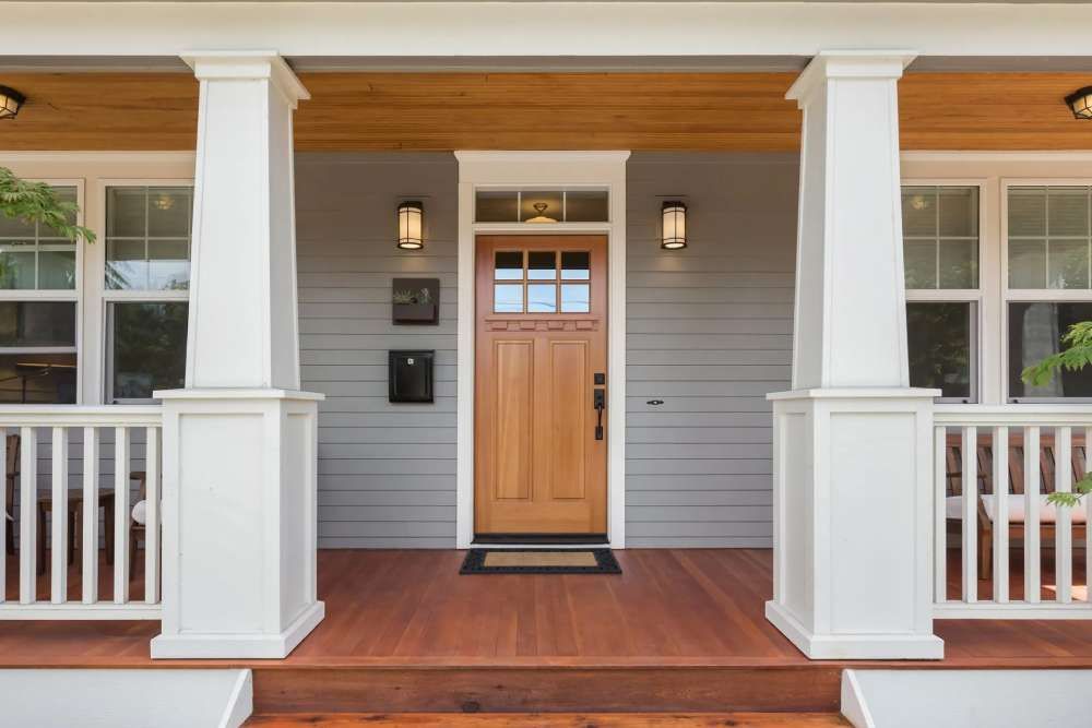 Front porch of a home with a natural wood door in Huntsville AL by LJ Roofing