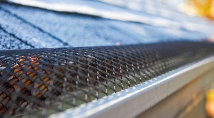 A close-up of a black metal gutter guard screen ion a home in Huntsville, AL by LJ Roofing