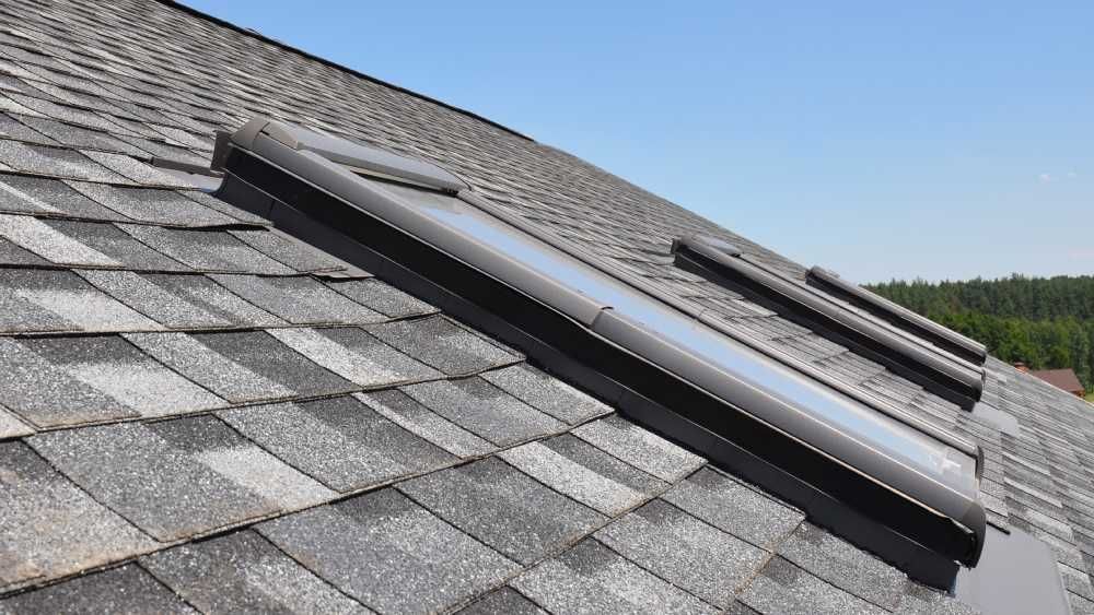 Two dark-framed skylights installed on a sloped roof covered in grey asphalt shingles in Huntsville AL by LJ Roofing