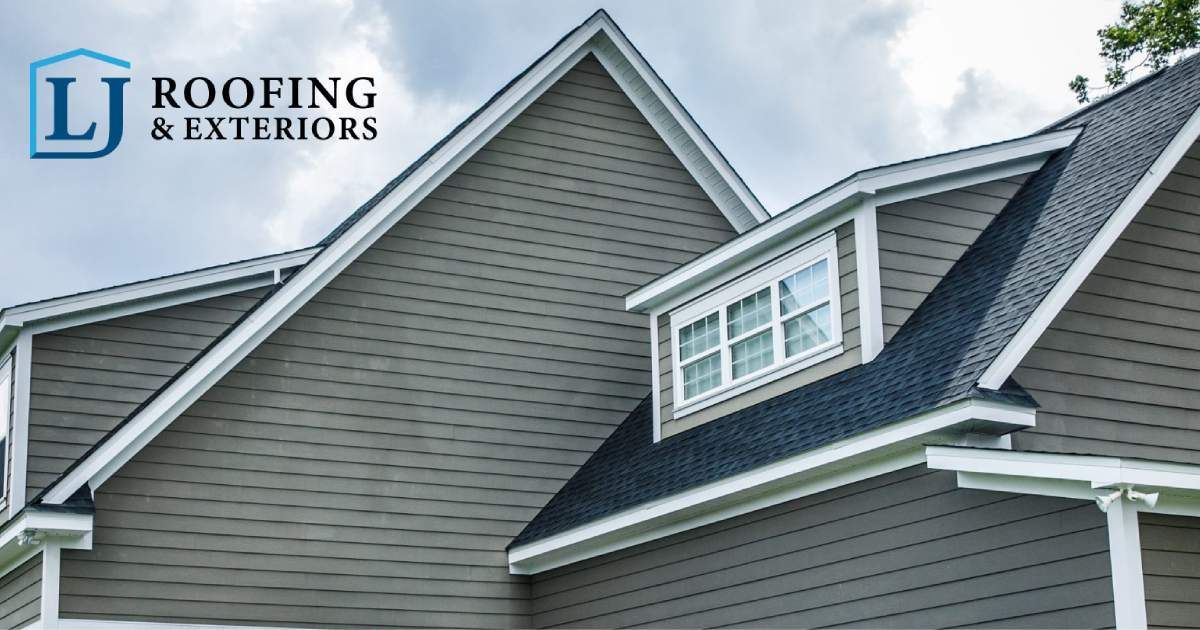 A house exterior with grey horizontal siding and a dark shingled roof, featuring a dormer window and an LJ Roofing logo.