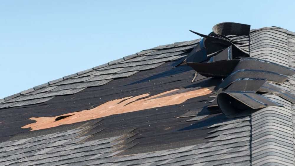 Damaged roof with missing and curled dark shingles roofing material in Huntsville AL by LJ Roofing