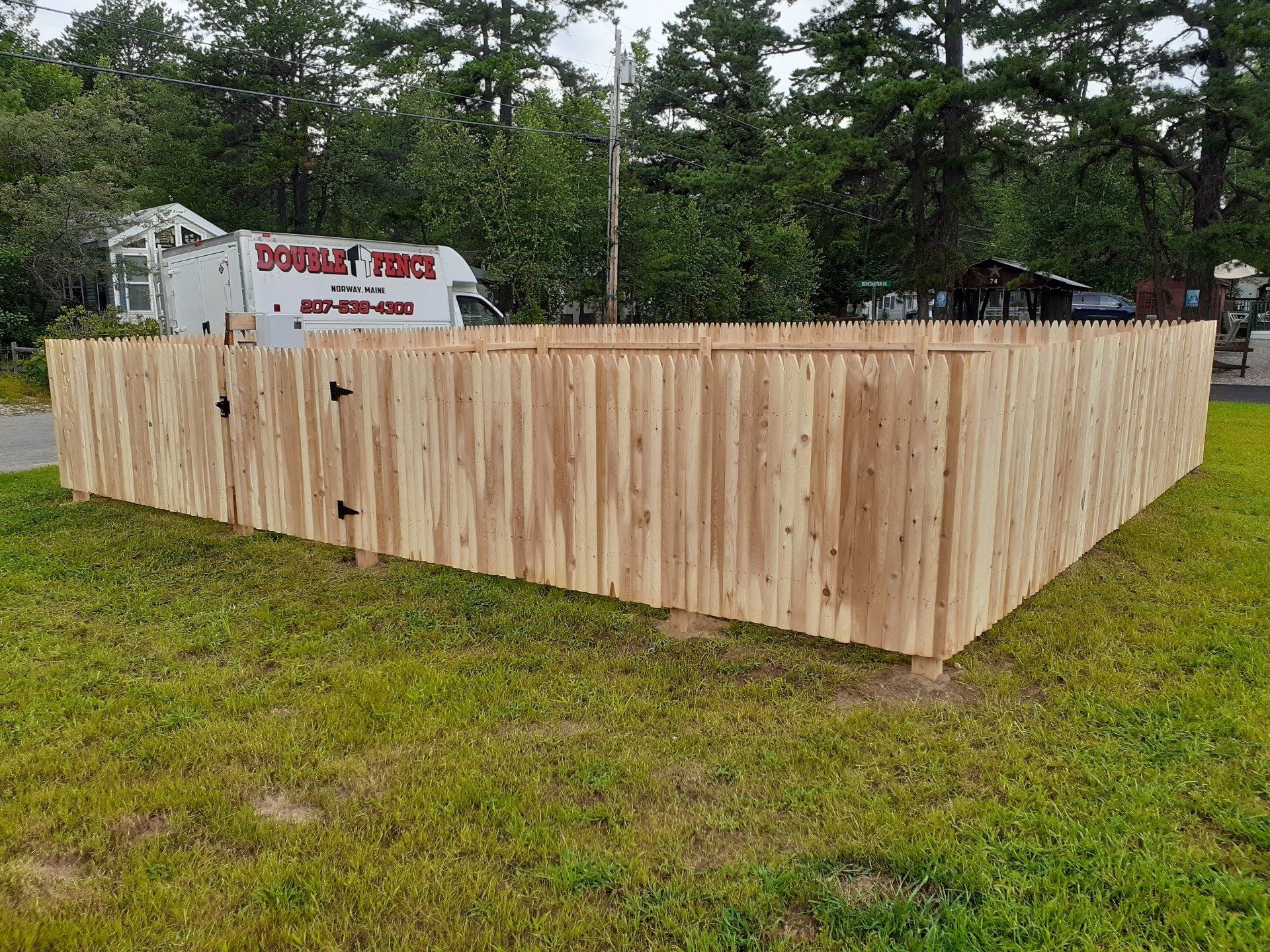 a wooden fence is sitting in the middle of a lush green field .