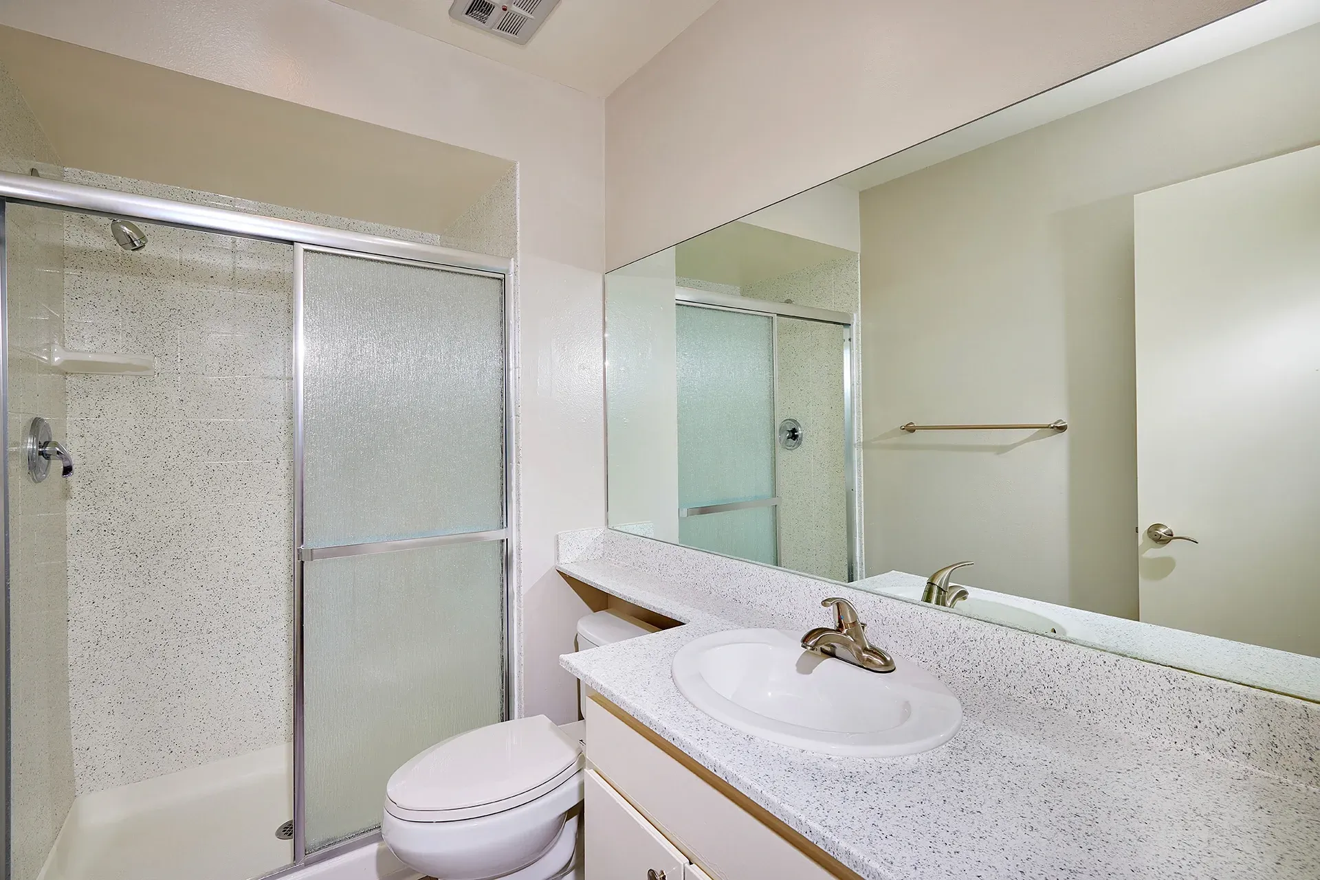 Bathroom with a toilet, sink, and glass-enclosed shower.