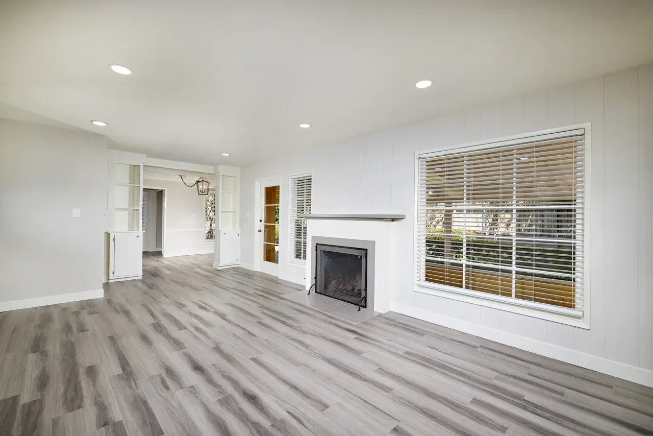 Spacious living room with a fireplace and large window.