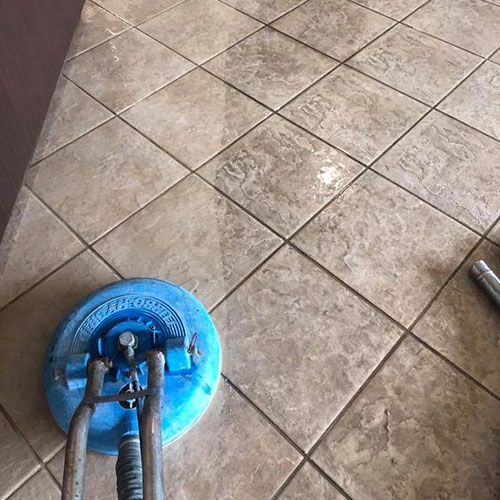 A tile floor is being cleaned with a machine.