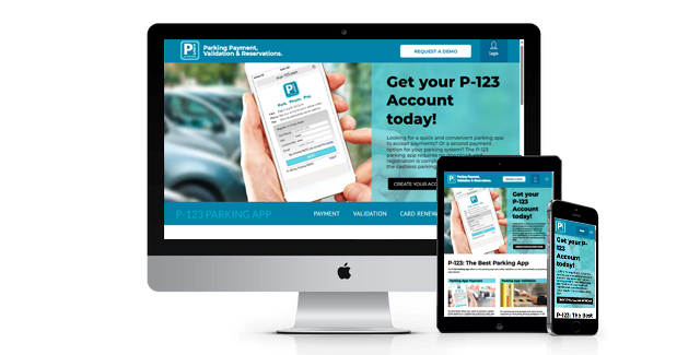 A person is holding a cell phone in front of a computer screen.