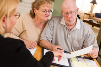Senior adult couple going over papers with an agent to apply for senior housing Senior adult couple going over papers with an agent to apply for senior housing
