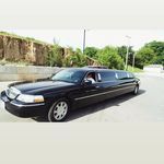 A black limousine is parked on the side of the road.