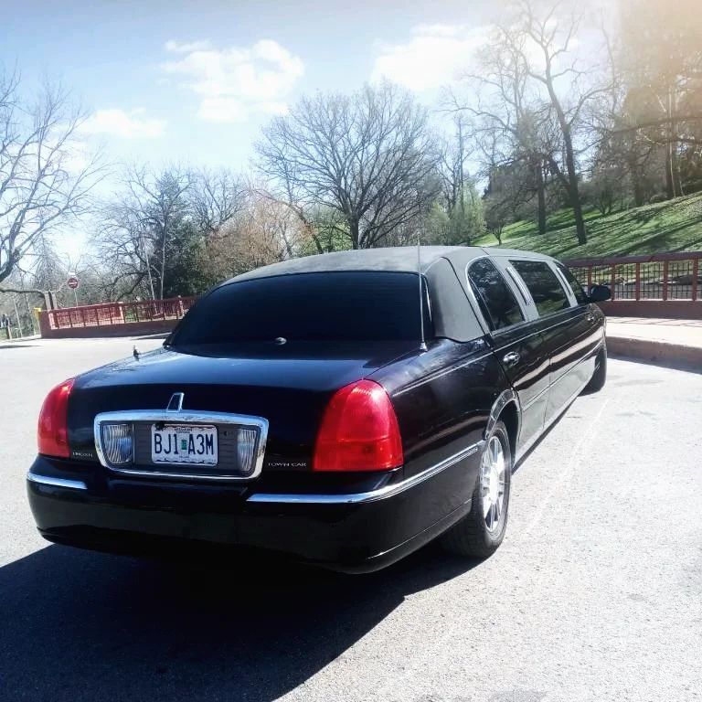 A black limousine with a license plate that says bjt03n