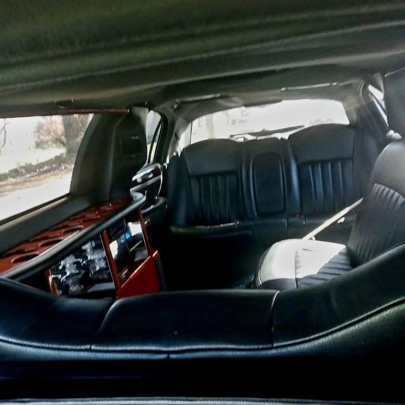 The back seat of a limousine with black leather seats