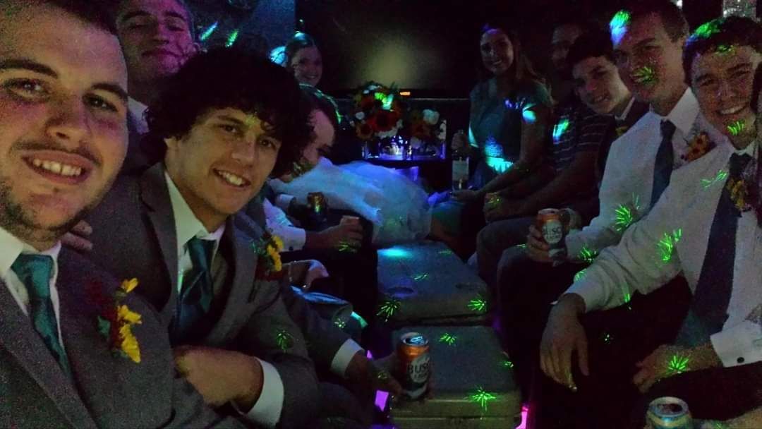 A group of men are sitting in a limousine taking a selfie.