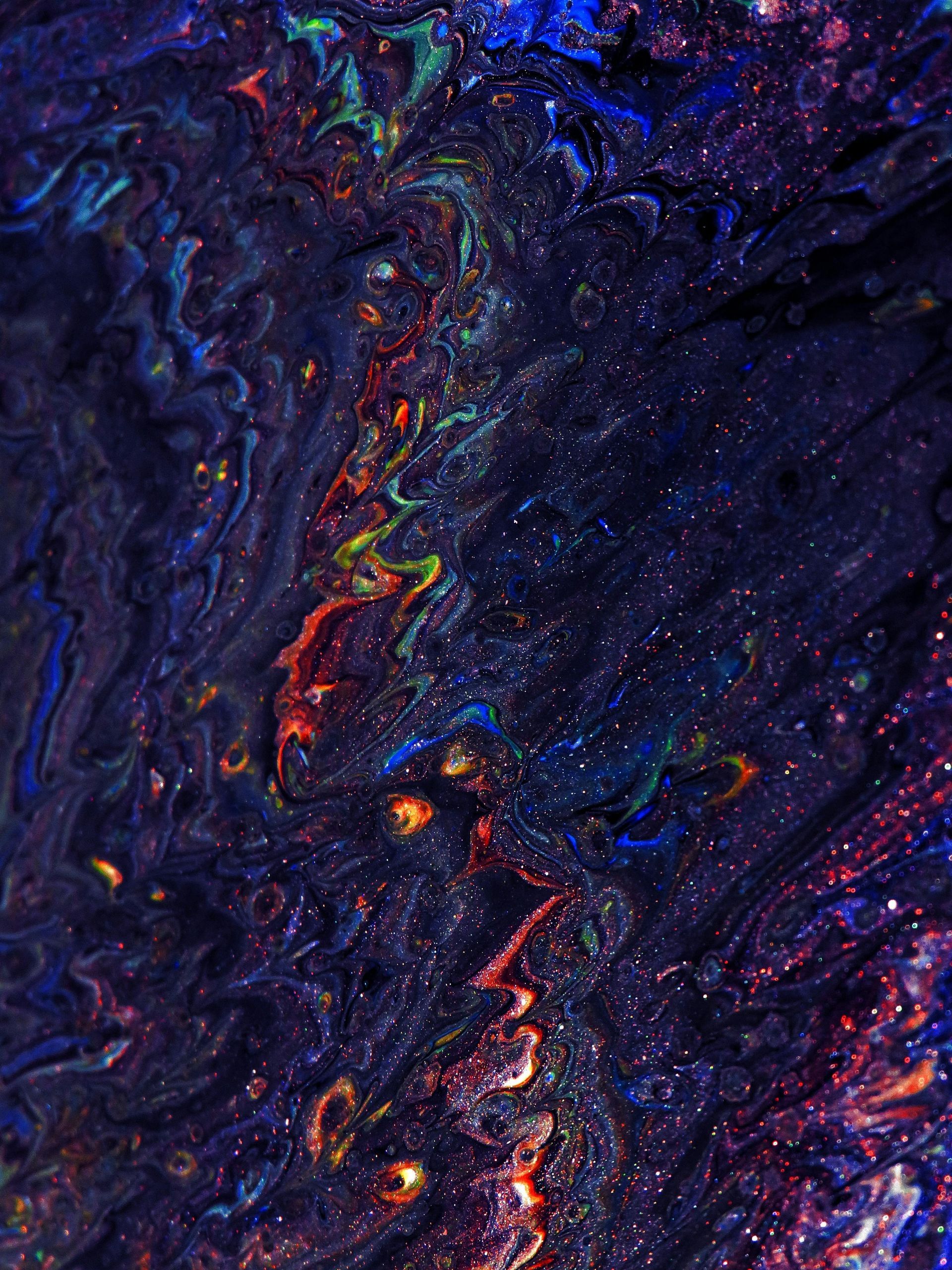 Abstract swirling art with dark blue, orange, and green colors, resembling a nebula or cosmic scene. SPATIAL FINE ARTS