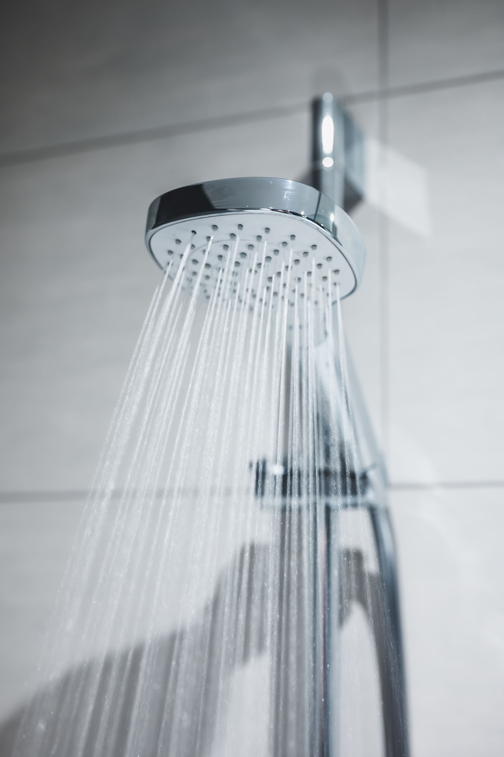 A close up of a shower head with water coming out of it.