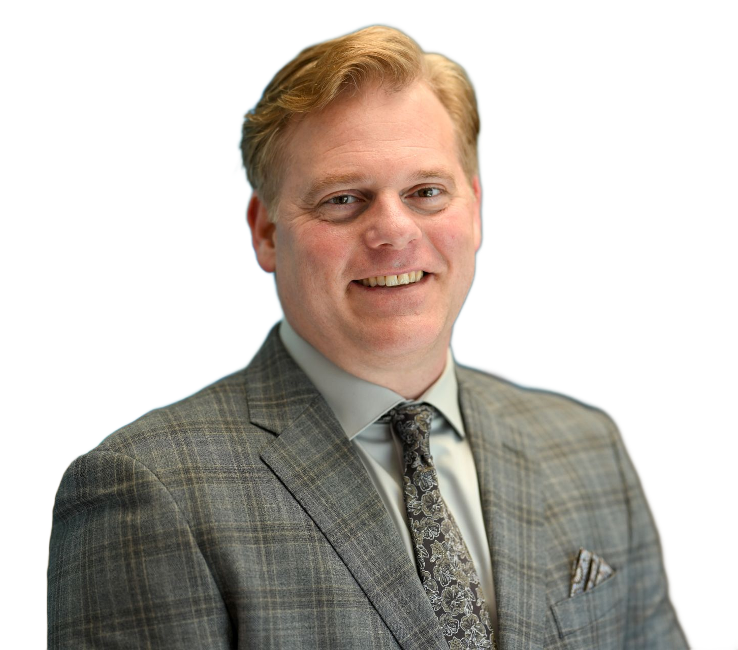 Man in a gray suit smiles, looking at the viewer. He has light hair and a patterned tie.