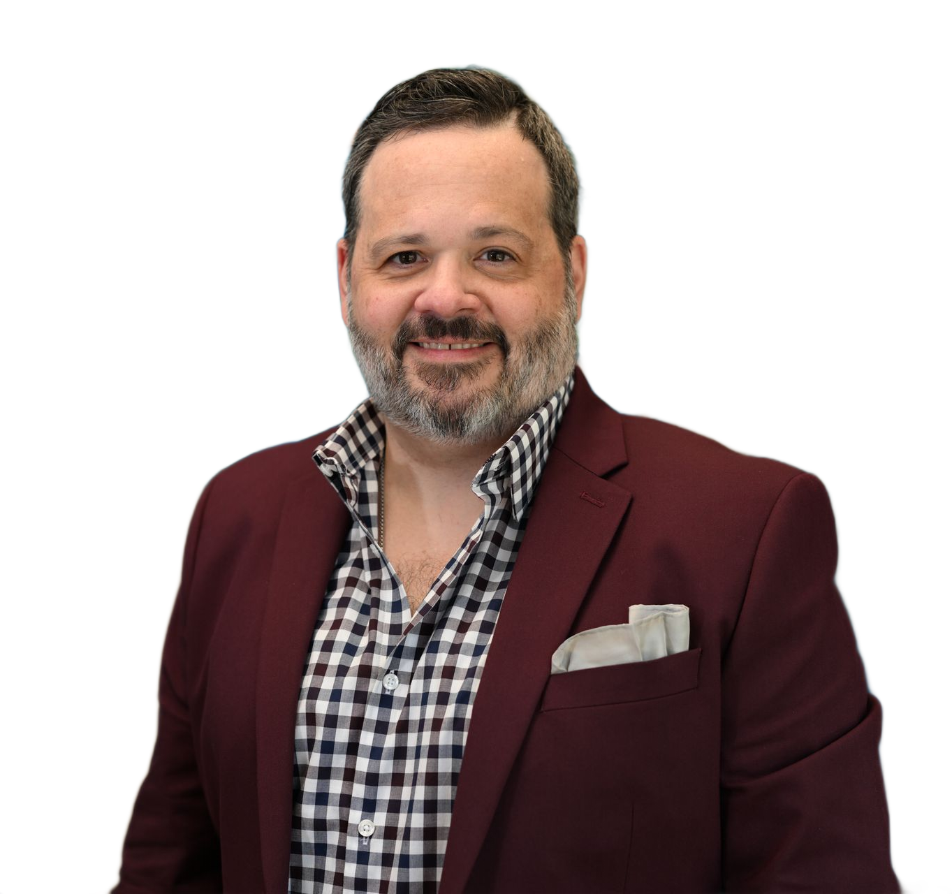 Man smiling, wearing a burgundy blazer over a checkered shirt, with a pocket square.